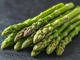 Long fresh asparagus spears lie neatly arranged against white background highlighting their vibrant green hues and detailed textured tips providing visual feast for food lovers photo