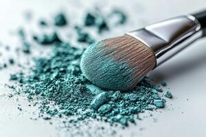 fluffy makeup brush dips into pressed eyeshadow pan picking up bright teal powder while soft particles scatter across clean white surface enhancing visual texture and color photo