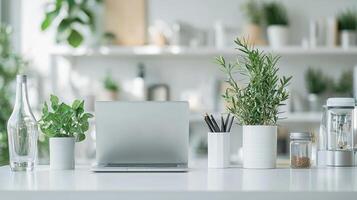 Sleek white desk showcases silver laptop surrounded lush green plants offering inviting and calming atmosphere enhanced natural light from window photo