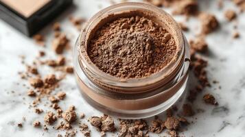Rich brown loose face powder is elegantly displayed in open jar delicate dusting on surface. Soft warm lighting highlights its silky texture and deep hue photo
