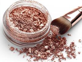 jar filled shimmering rose gold eyeshadow pigment showcases its beauty as soft brush dips into powder spilling some onto pristine white surface beneath photo