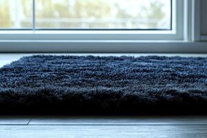 Soft fibers of deep gray rug create warm and inviting ambiance beside bed illuminated gentle lighting against white backdrop. Perfect for cozy interiors photo