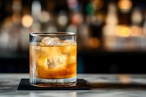 A glass of whiskey sitting on a bar counter photo