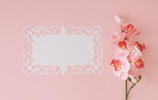 Orchid flower on light pastel pink background with white paper card note copy space. Minimal spring and summer concept. Flowers aesthetic. Flat lay, top of view. photo