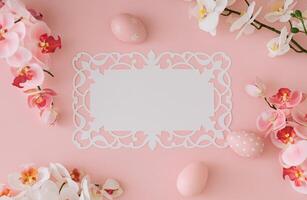 Spring composition made with pink colored Easter eggs and orchid flowers with paper card copy space on light pastel pink background. Minimal Easter concept. Creative festive holiday layout. Flat lay. photo