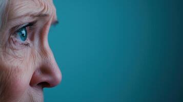 Elderly Woman Crying Closeup View on Blue Background in Cinematic 16-9 Aspect Ratio Highlighting Emotional Depth and Raw Beauty photo