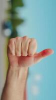 Close-up of a hand giving a thumbs-up gesture against a blurred outdoor background Approval and positivity concept symbolizing success, agreement, and encouragement photo