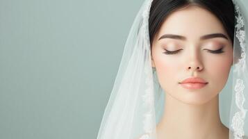 Bride with closed eyes wearing a delicate lace veil against a soft pastel background Close-up portrait for wedding celebration and design photo