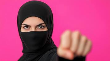 Woman in Hijab Practicing Martial Arts Against Vibrant Pink Background Exhibiting Strength and Focus in Modern Self Defense and Cultural Expression photo
