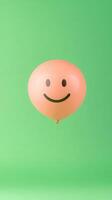 Smiley Face Balloon Against Green Background Reflecting Joy and Social Media Trends photo