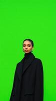 Fashion Model in Black Coat Against Vibrant Green Screen Background at Photo Shoot for Modern Design and Visual Effects Application
