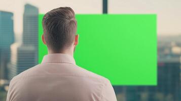 Man Viewing Urban Scene Through Green Screen Banner in Office Setting for Digital Design and Presentation Use photo