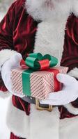 cerca arriba de Papa Noel con regalo, Nevado antecedentes mejorando festivo alegría vertical móvil fondo de pantalla foto