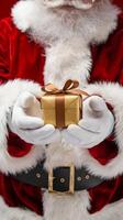santas manos presentación un dorado regalo caja, festivo cerca arriba vertical móvil fondo de pantalla foto