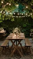 Rustic wooden table bathed in warm light, with green foliage and cozy string lights. Vertical Mobile Wallpaper photo