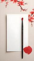 A red ink Chinese calligraphy brush, positioned against a soft, neutral background, ready to write New Year wishes, with room for text. photo