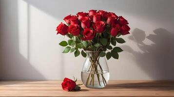 A bunch of fresh red roses in a glass vase, placed on a wooden surface, with natural shadows adding depth and plenty of room for a personalized message. photo