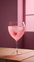 The heart-shaped glass of pink lemonade is placed on a wooden surface, with soft lighting highlighting its design and leaving room for a message. photo
