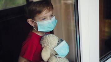 a boy with a toy in a mask waves out the window video