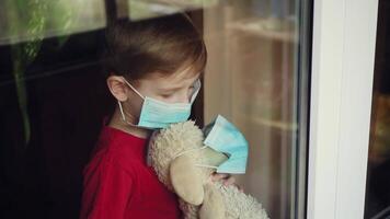 a boy with a toy in a mask looks out the window video