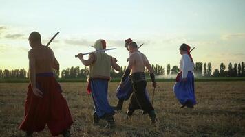 Group of Cossack men in traditional clothes swinging and spinning sharp shashkas 01 video