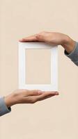 Hands present an empty white frame, emphasizing simplicity and creative possibilities Vertical Mobile Wallpaper photo