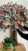 un vibrante papel árbol adornado con vistoso hojas, con un tranquilo verde planta abajo vertical móvil fondo de pantalla foto