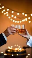 Whiskey glasses clinking, celebration with warm backdrop and string lights Vertical Mobile Wallpaper photo