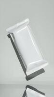 White packaging pouch floating on gray background, sealed minimalist design Vertical Mobile Wallpaper photo