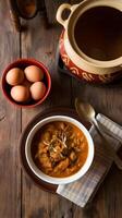 Rustic table with red bowl of eggs and stew, evoking homely warmth Vertical Mobile Wallpaper photo