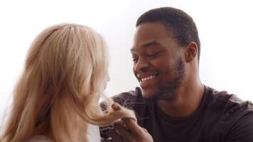 A loving biracial couple shares intimate moments at home, enjoying each other's company. Their expressions reflect happiness and deep affection, highlighting their strong bond and commitment. video