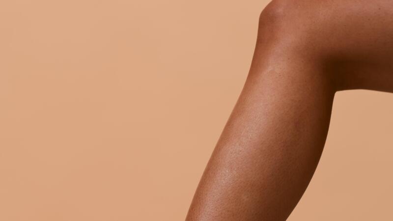 A young African American woman is applying hair removing ... 