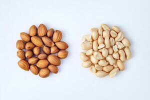 Almonds and peanuts forming two roundish heaps on white background photo
