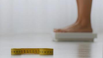 A measuring tape is placed on a table, highlighting the focus on fitness and health. The background suggests a home workout setting, emphasizing personal fitness tracking. video