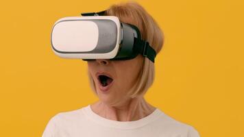 A woman shows enthusiasm while wearing a virtual reality headset, fully engaged in a digital experience, with her surprised expression highlighted against a vibrant yellow background. video