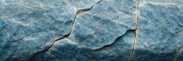 Natural stone texture with prominent cracks and blue tones reflecting geological patterns photo