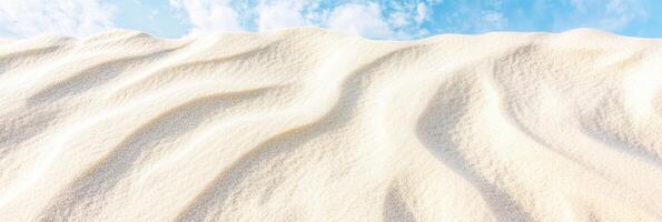 Wavy sand dune patterns under clear blue sky in desert landscape photo
