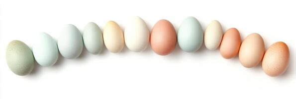 Multi-colored chicken eggs arranged in curved line on white background photo
