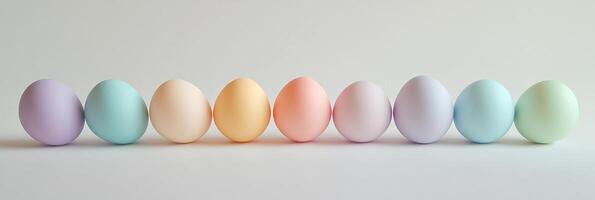 Pastel-hued easter eggs in a neat row on a neutral background photo