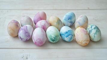 Pastel colored easter eggs with watercolor patterns on wooden table surface photo