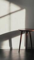 Sunlit Minimalist Interior Design A Wooden Side Table Basking in Sunlight Against a White Wall photo