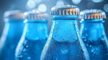 Blue glass soda bottles line up perfectly, displaying carbonated beverages with condensation drops, creating refreshing summer vibes against soft bokeh background. glass photo