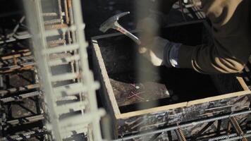 Worker assembling wooden formwork at construction site video