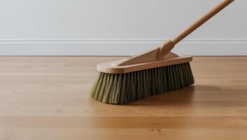 Sustainable cleaning with a wooden broom on hardwood floors, highlighting natural bristles as a plastic-free alternative. photo