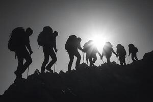 Silhouetted hikers ascend a challenging mountain peak photo