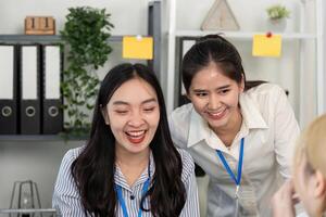 Two business professionals sharing a joyful moment while collaborating in an office photo