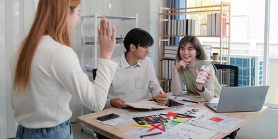 Creative UX UI team collaborating on design project in a modern office, showcasing diverse professionals photo