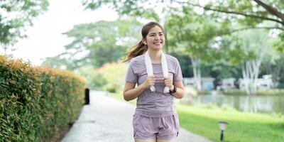 Happy young woman jogging in a vibrant park, embracing fitness and outdoor enjoyment photo