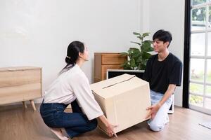 Dedicated couple working together to lift a moving box in their new home, showcasing teamwork and collaboration photo