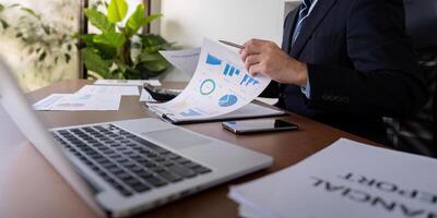 Accountant reviewing financial reports while analyzing charts and graphs in a modern office photo